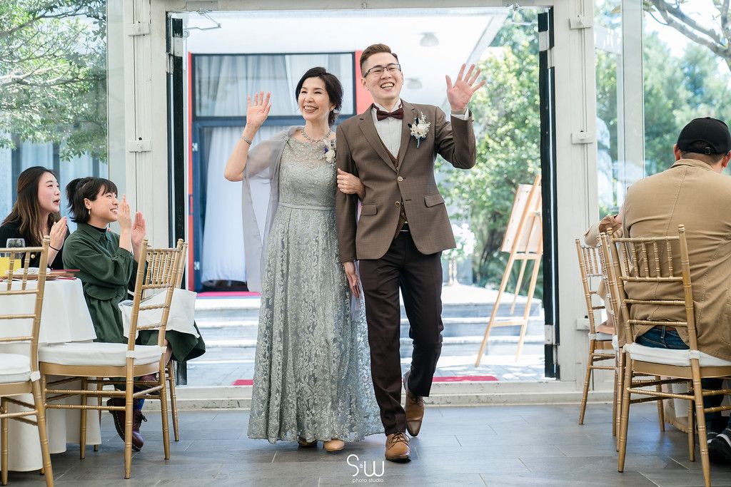 Wedding exit with celebratory waves through venue lined with gold chairs.