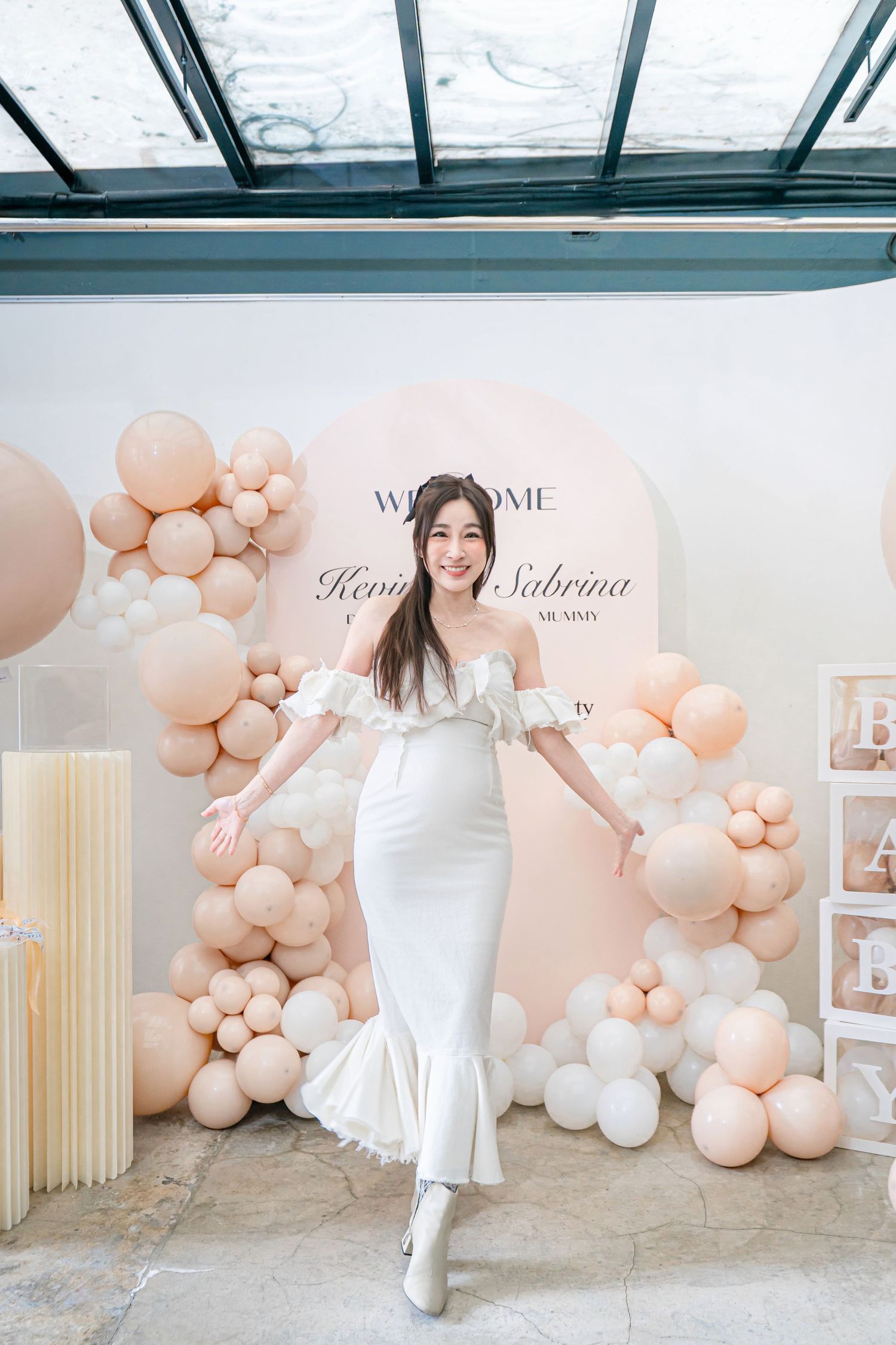 Elegant event space decorated with blush pink and white balloon garlands against a light neutral backdrop.