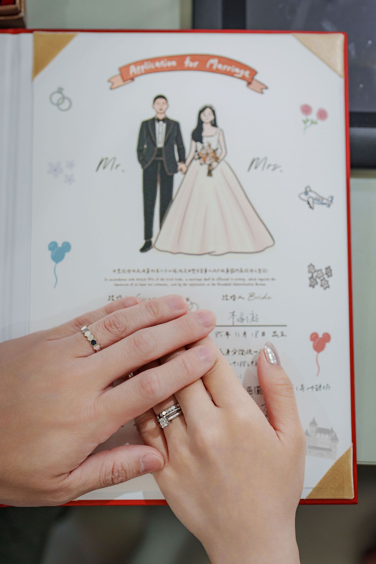 Wedding invitation illustrations showing bride and groom figures with hands displaying rings in closeup shots.
