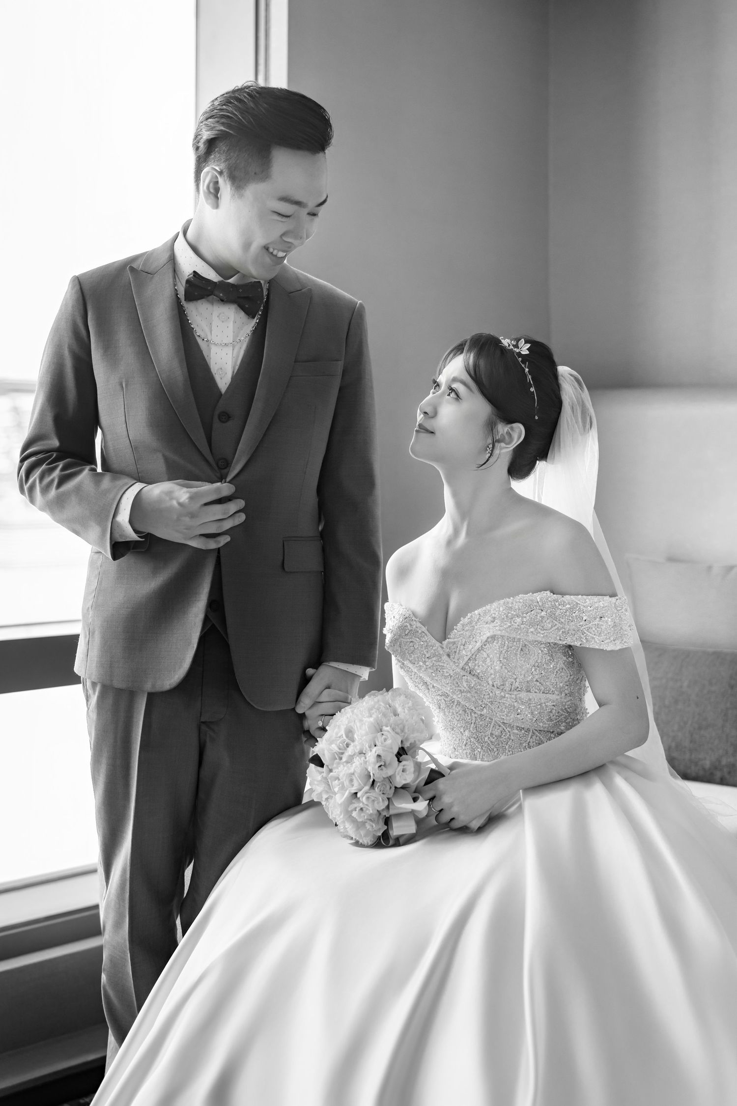 A tender moment between newlyweds in formal attire sharing loving glances and embraces during their wedding photoshoot.