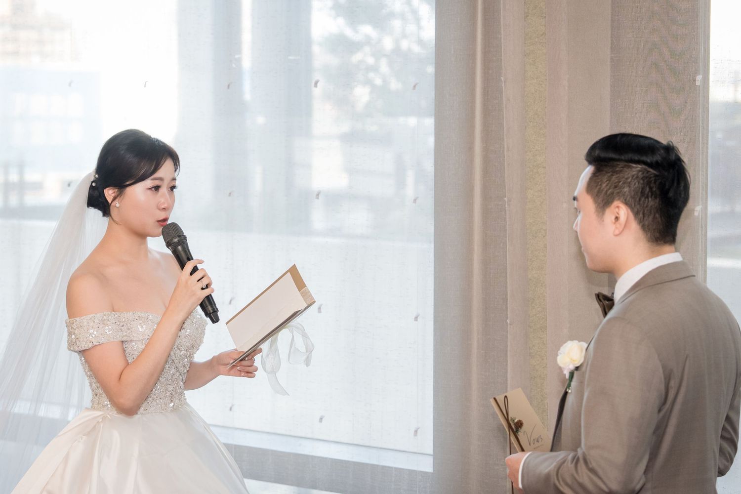 Business professionals in office attire having a conversation while holding documents and mobile phones.