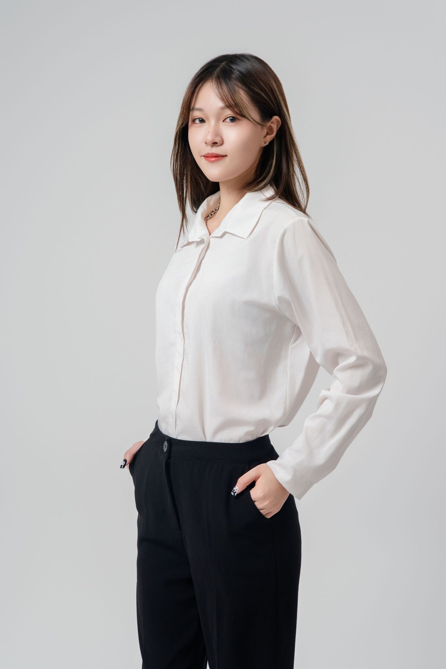 Professional fashion photo series showing a white collared blouse paired with black trousers against a light background.