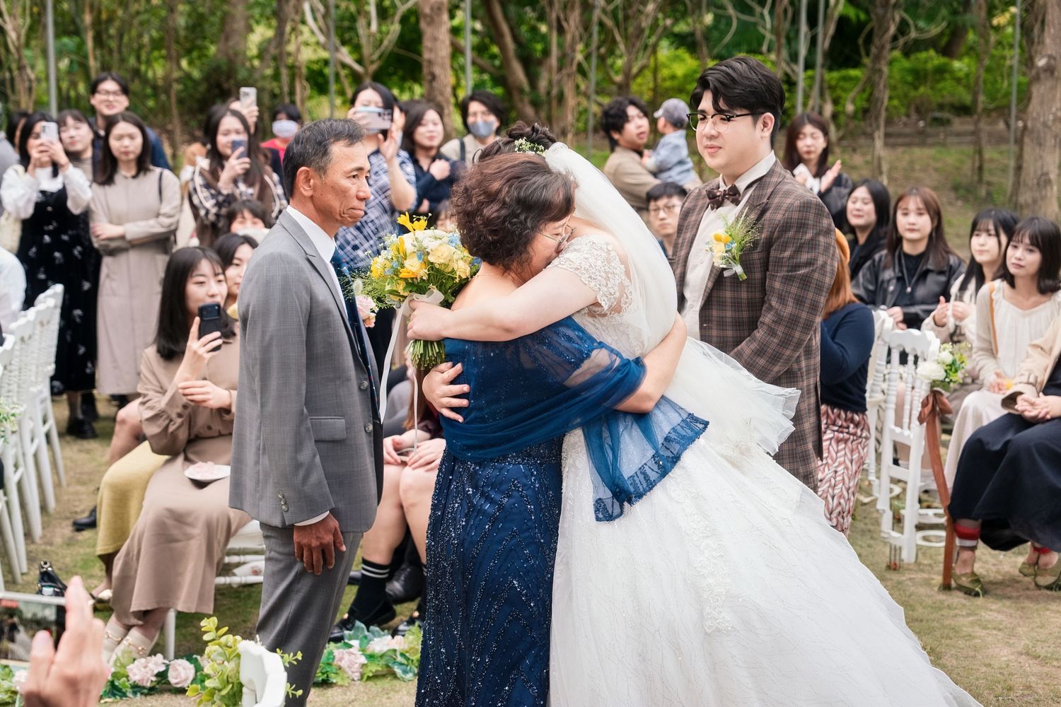 Wedding guests dance and celebrate together during an outdoor garden reception celebration.