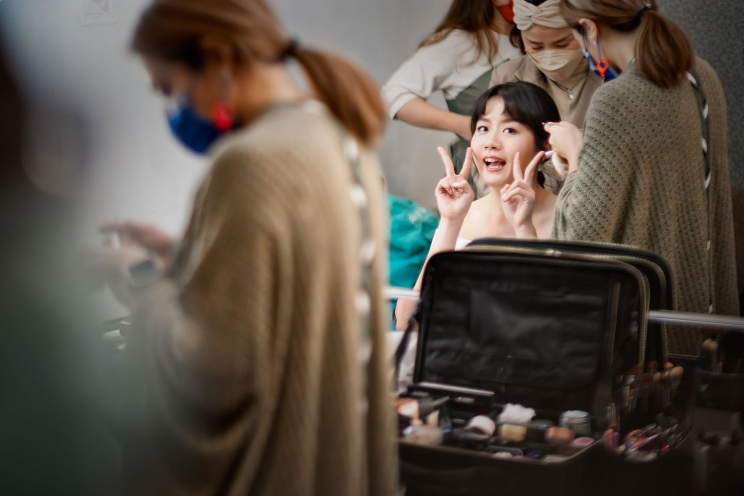 Behind the scenes shot of wedding preparation with makeup being applied.