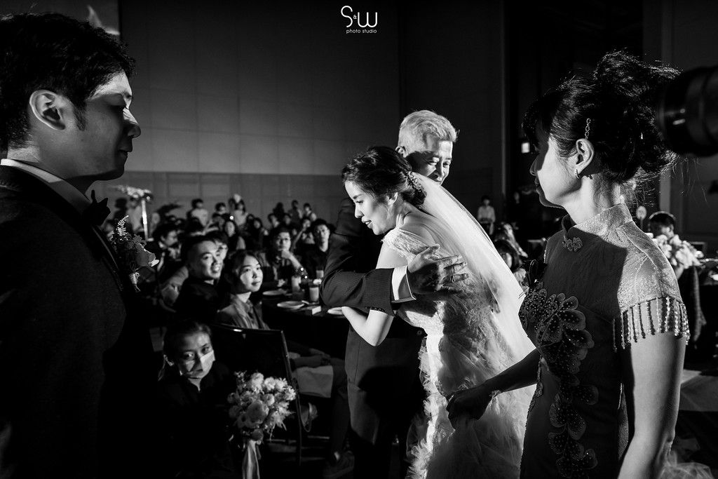 Black and white shot of wedding celebration with guests in attendance.