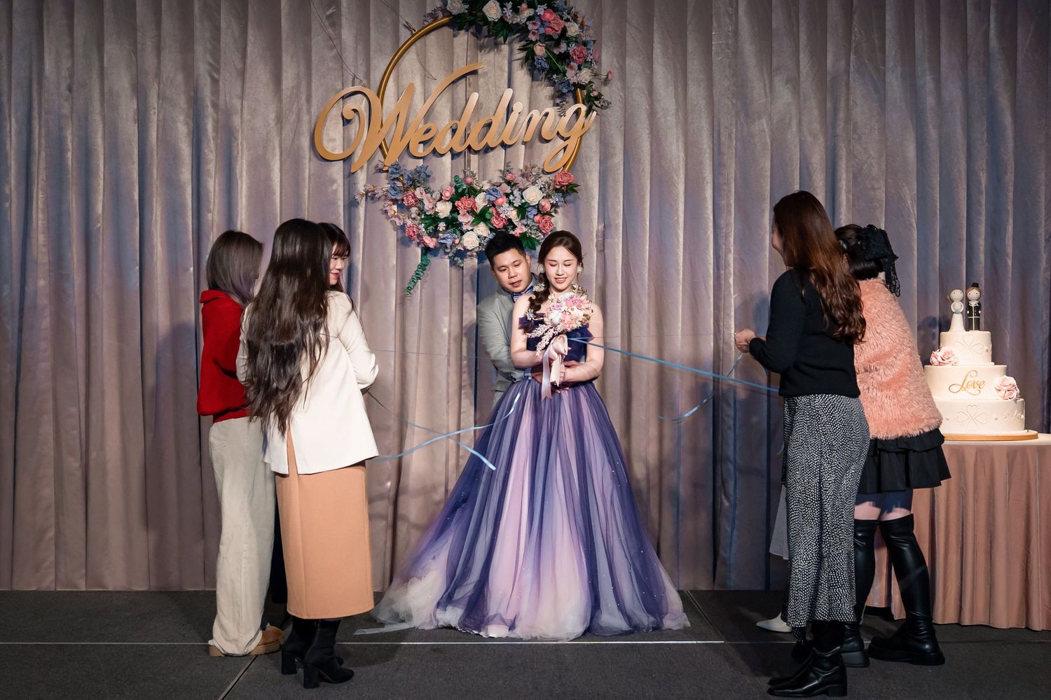 Wedding ceremony venue decorated with pink floral arrangements and elegant drapes creating a romantic atmosphere.