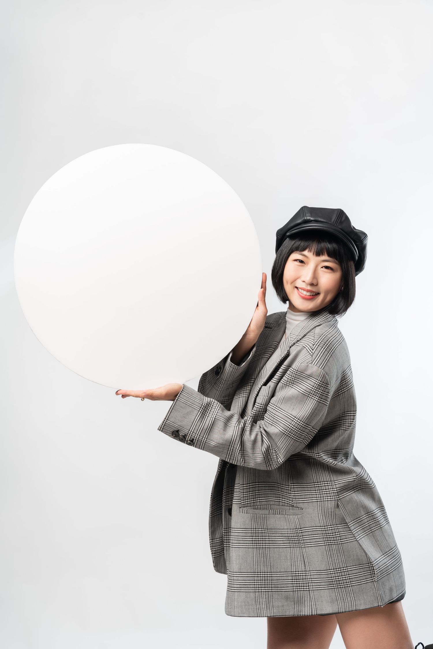 Person in gray plaid blazer and black hat poses playfully in four different dynamic poses against white background.