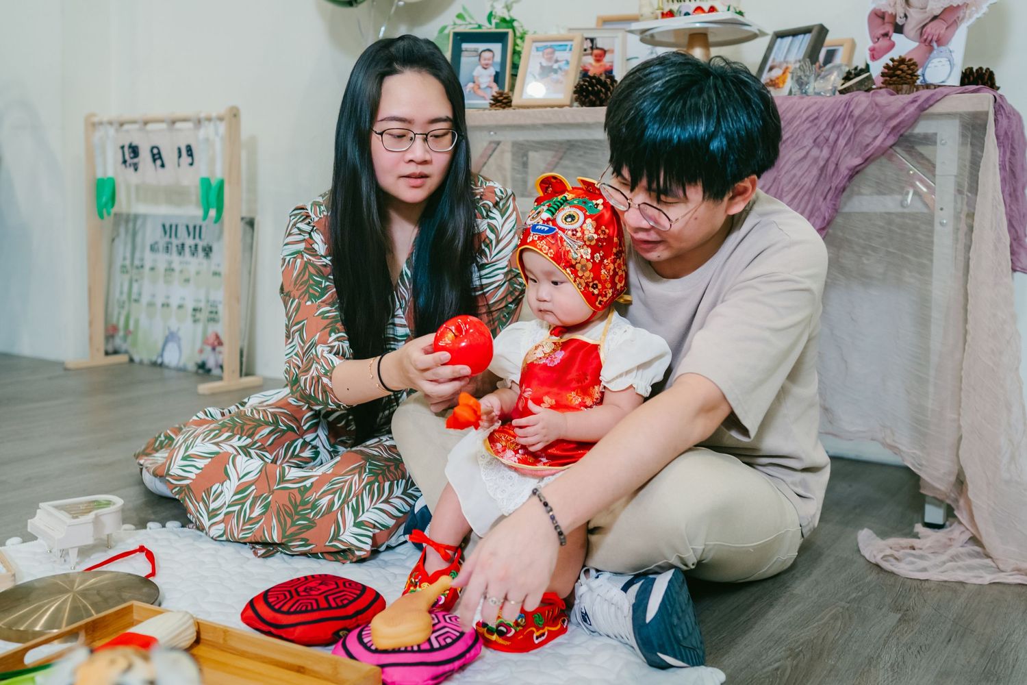 Family sitting on floor playing with toys together in their home during Chinese New Year celebration.