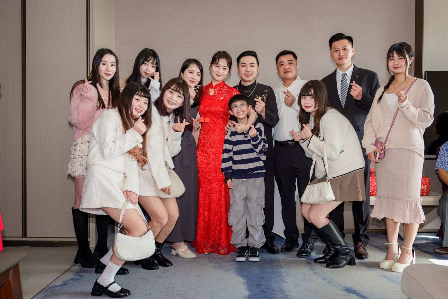 Group of people posing together at an indoor event wearing casual and formal attire.