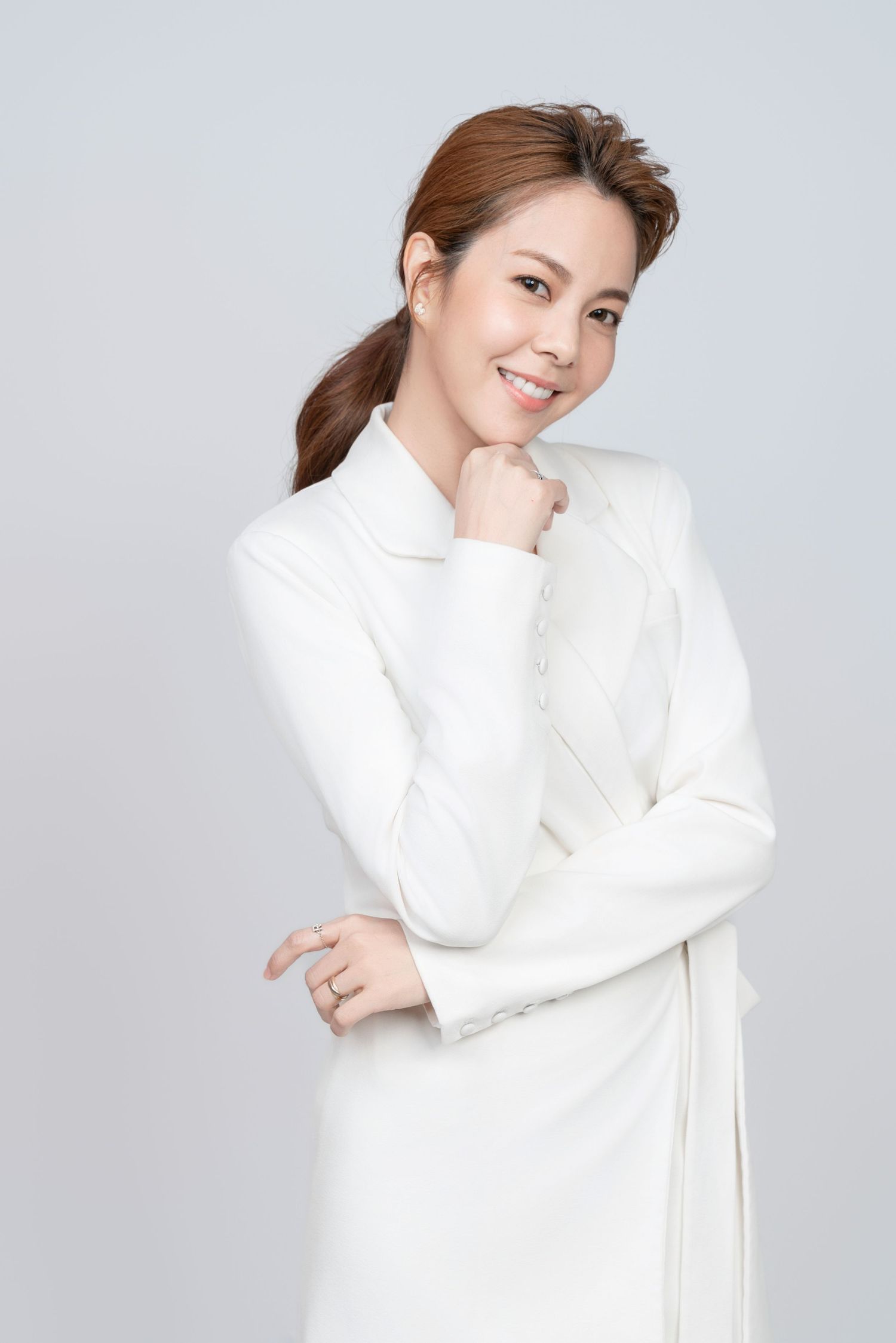 A person wearing a white sweater poses against a light gray background in a series of four casual portraits.