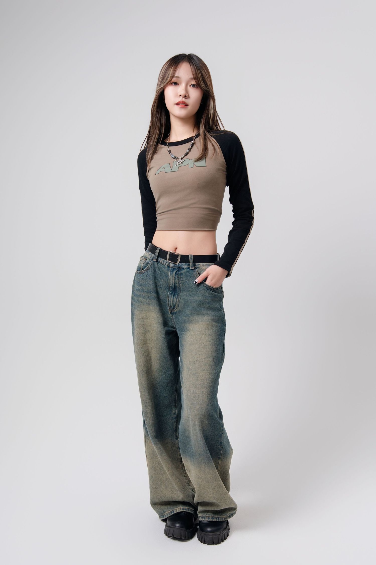A series of fashion photos showing casual outfit with beige crop top, black long sleeves and baggy light wash jeans.