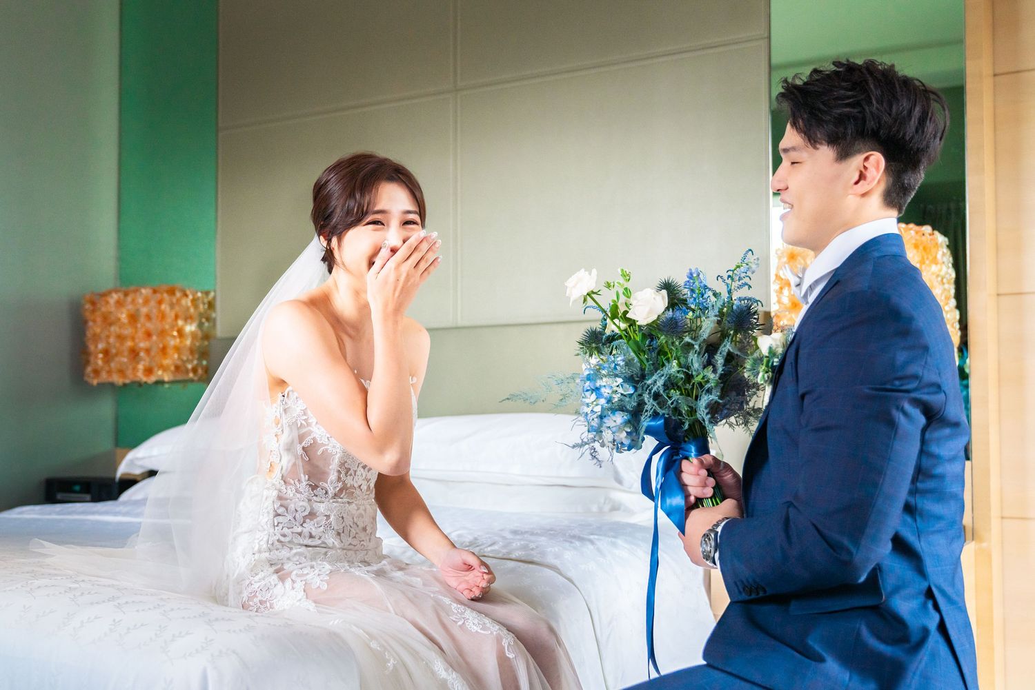 A joyful wedding scene showing a romantic moment with blue flowers and elegant formal attire.