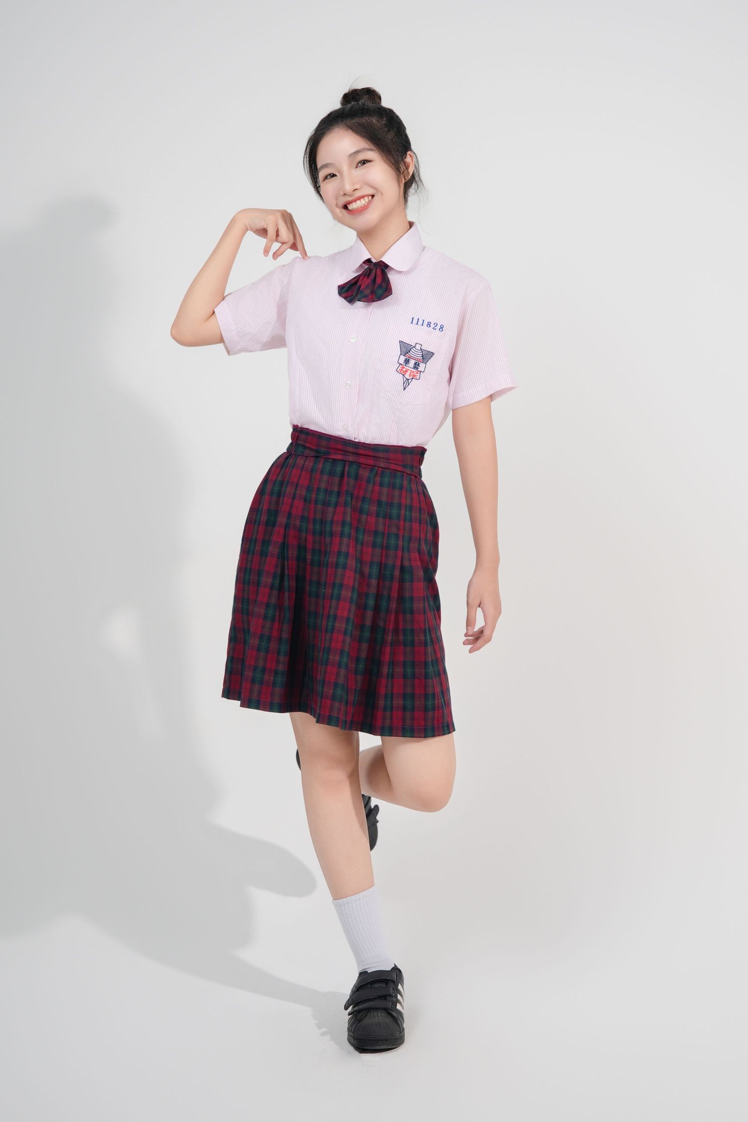School uniform style outfit featuring a pink polo shirt, plaid pleated skirt, white knee socks and black shoes.