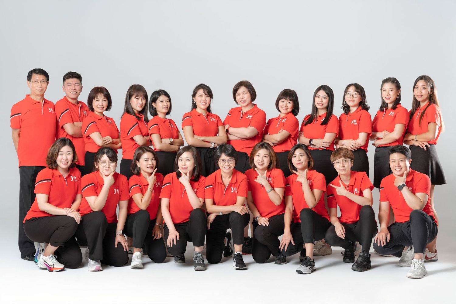 Group of athletes in matching red uniforms pose together for team photos in various formations.
