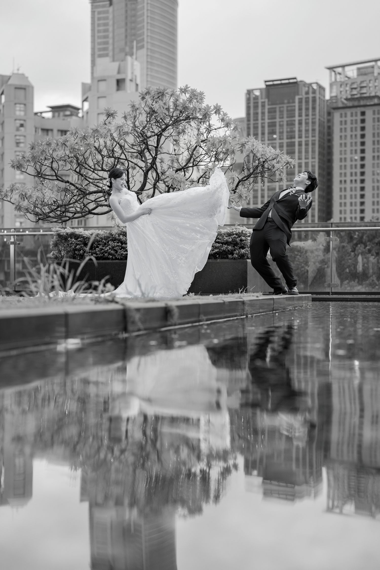 A dramatic wedding photoshoot sequence showing silhouettes against a cityscape backdrop with reflective water surface.