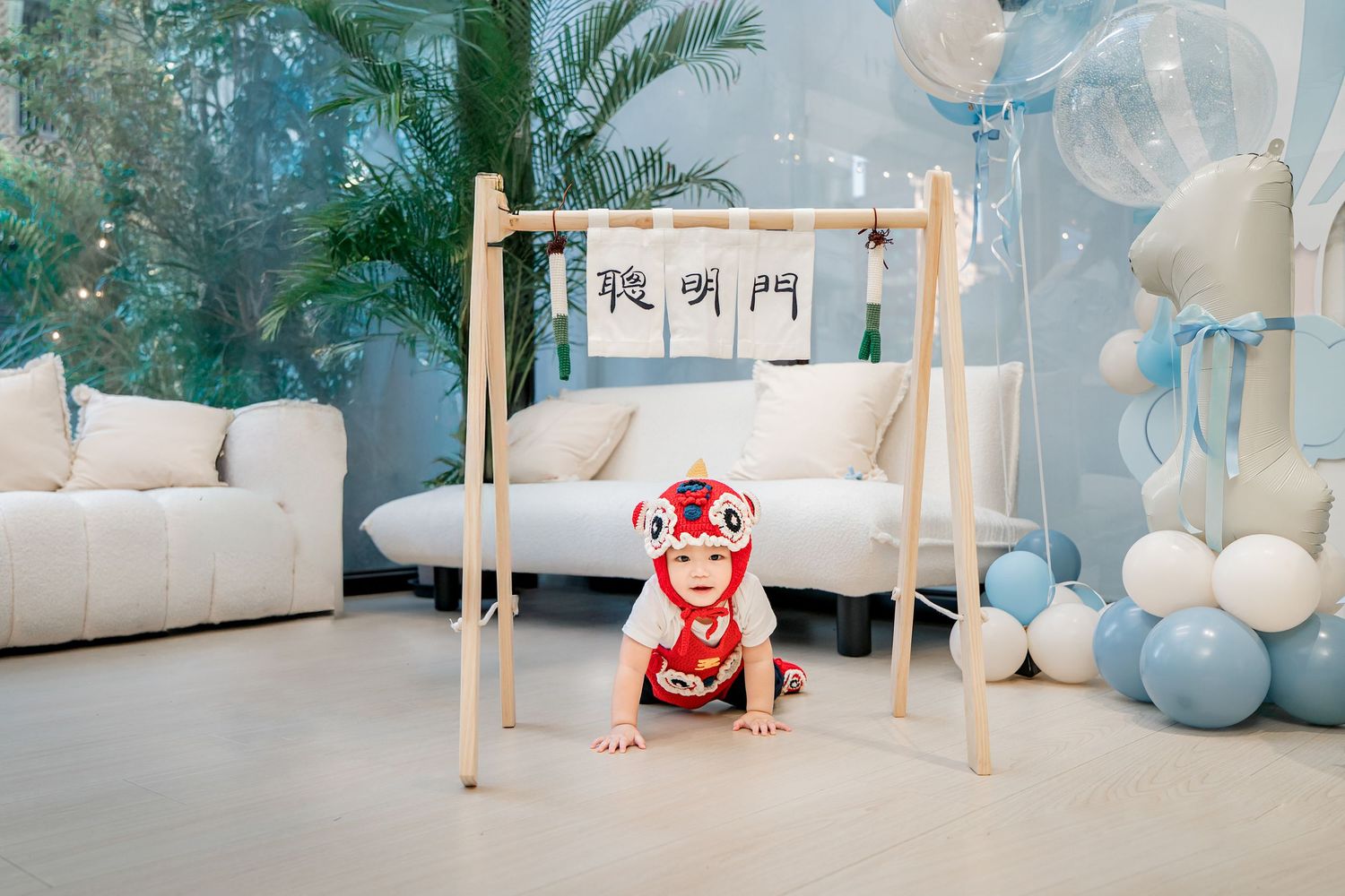 Minimalist white and blue studio setup with wooden ballet barre and soft balloon decorations against a pale backdrop.