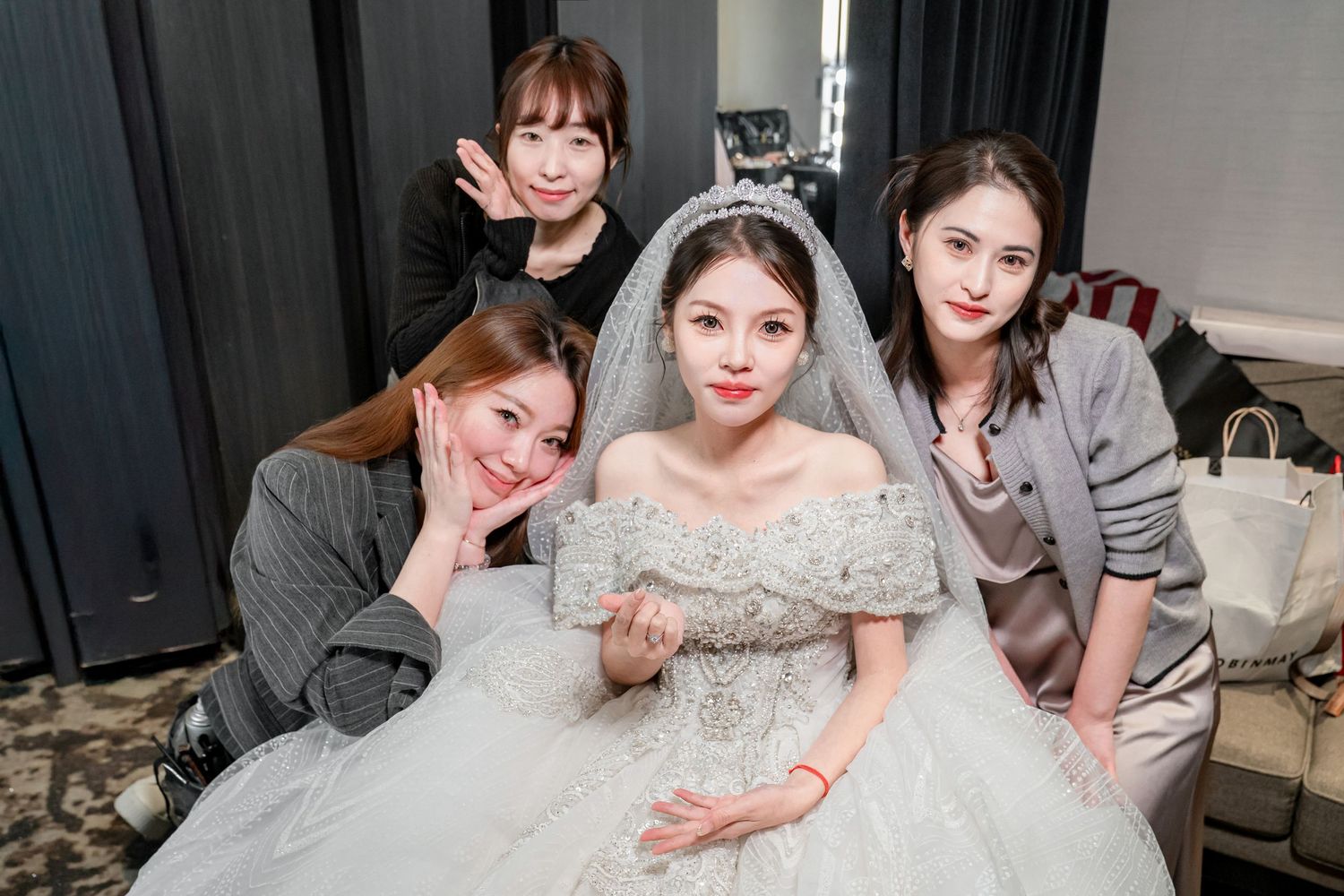 A group of people in formal attire pose together at a wedding celebration.