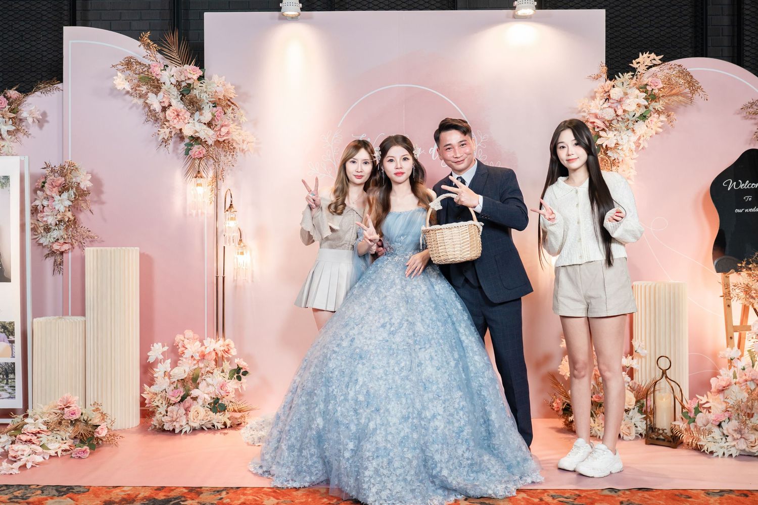 Elegant wedding reception venue decorated with soft pink floral arrangements and blue gown details in a romantic setting.