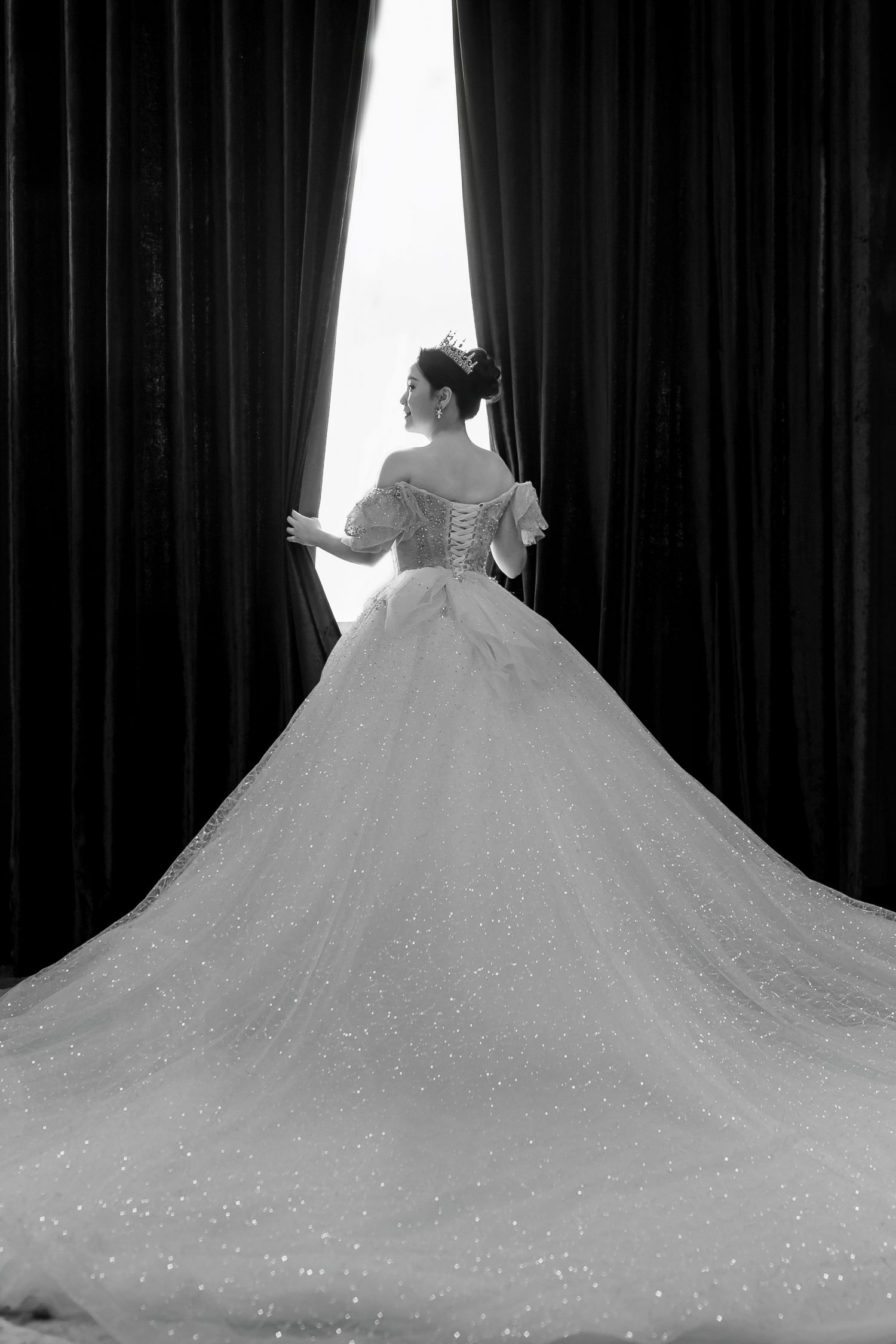 A series of four wedding dress silhouettes showing the dramatic sweep of a full skirt train against a dark backdrop.