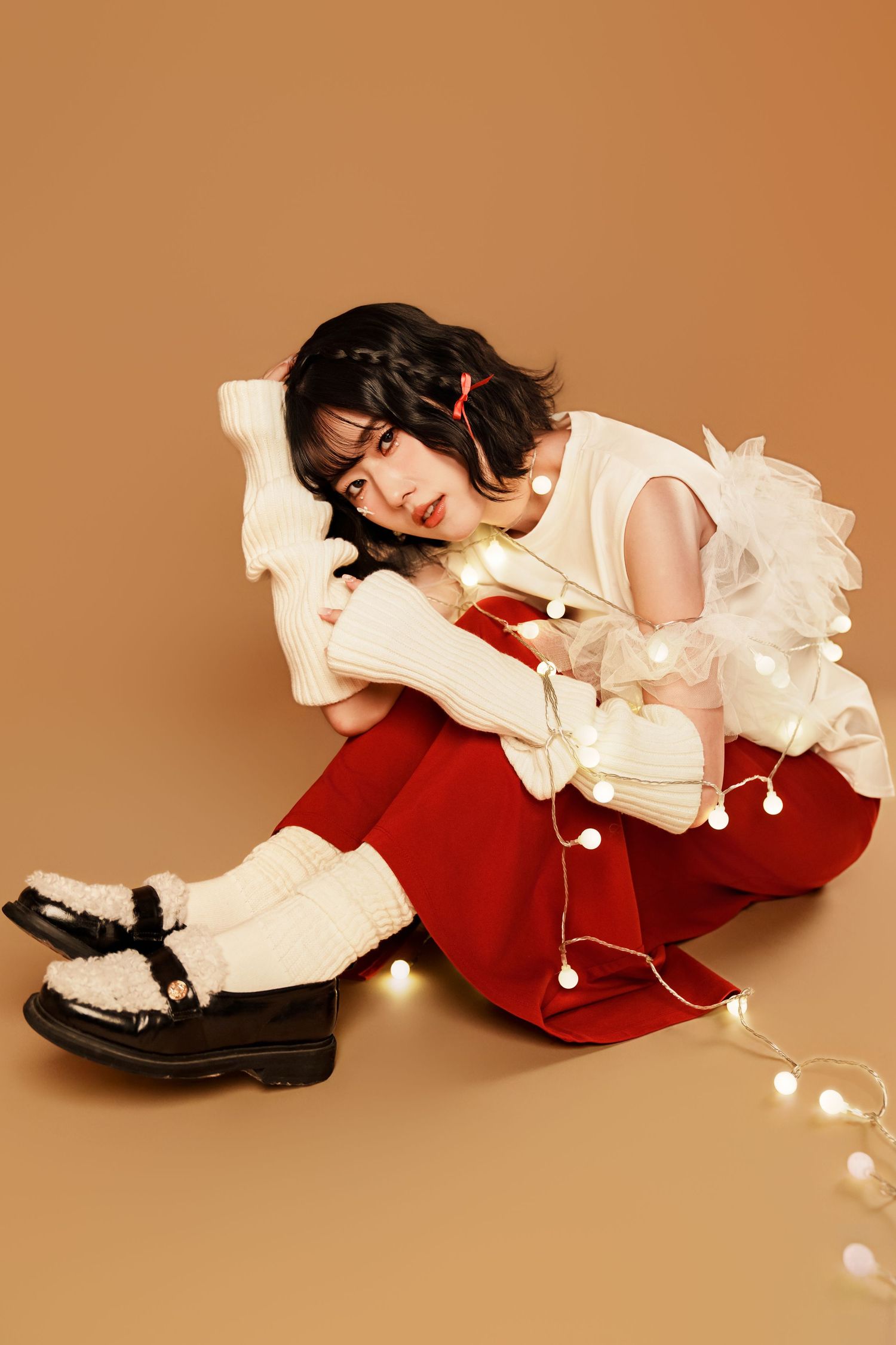 Artistic photo series showing a white ruffle blouse and red dress with fairy lights creating a dreamy atmosphere.