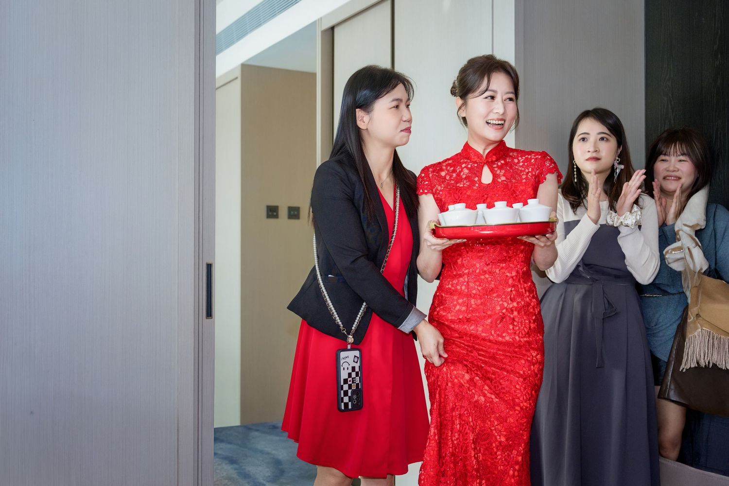 A group of people gather around a white birthday cake during a celebration party.