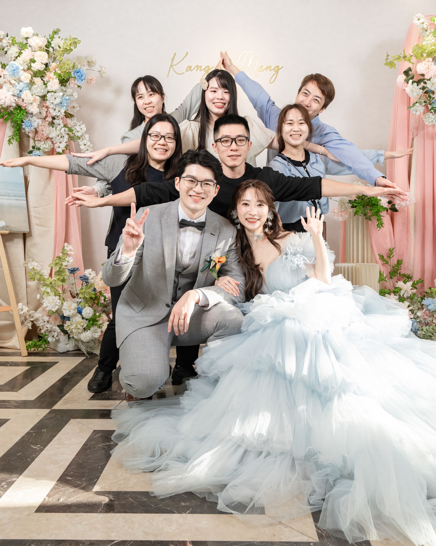 A wedding photo series showing joyful moments with guests and the couple in a light-filled venue with floral decorations.