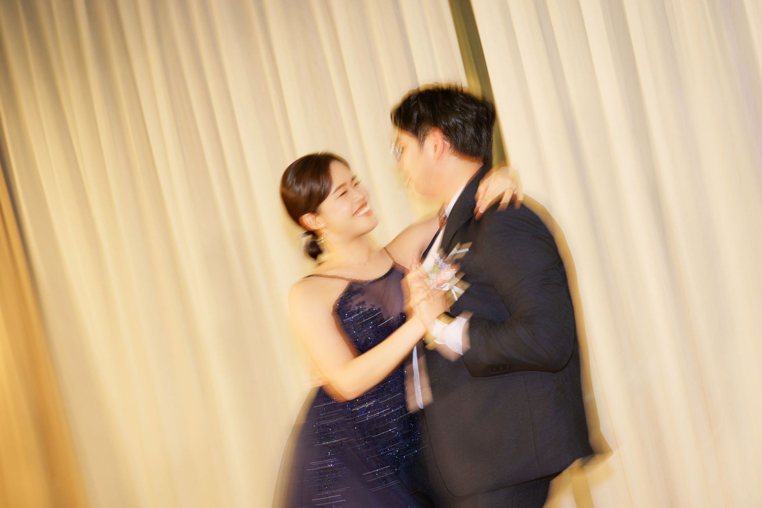 A couple dancing together in formal attire with multiple exposure effect showing movement and romance.