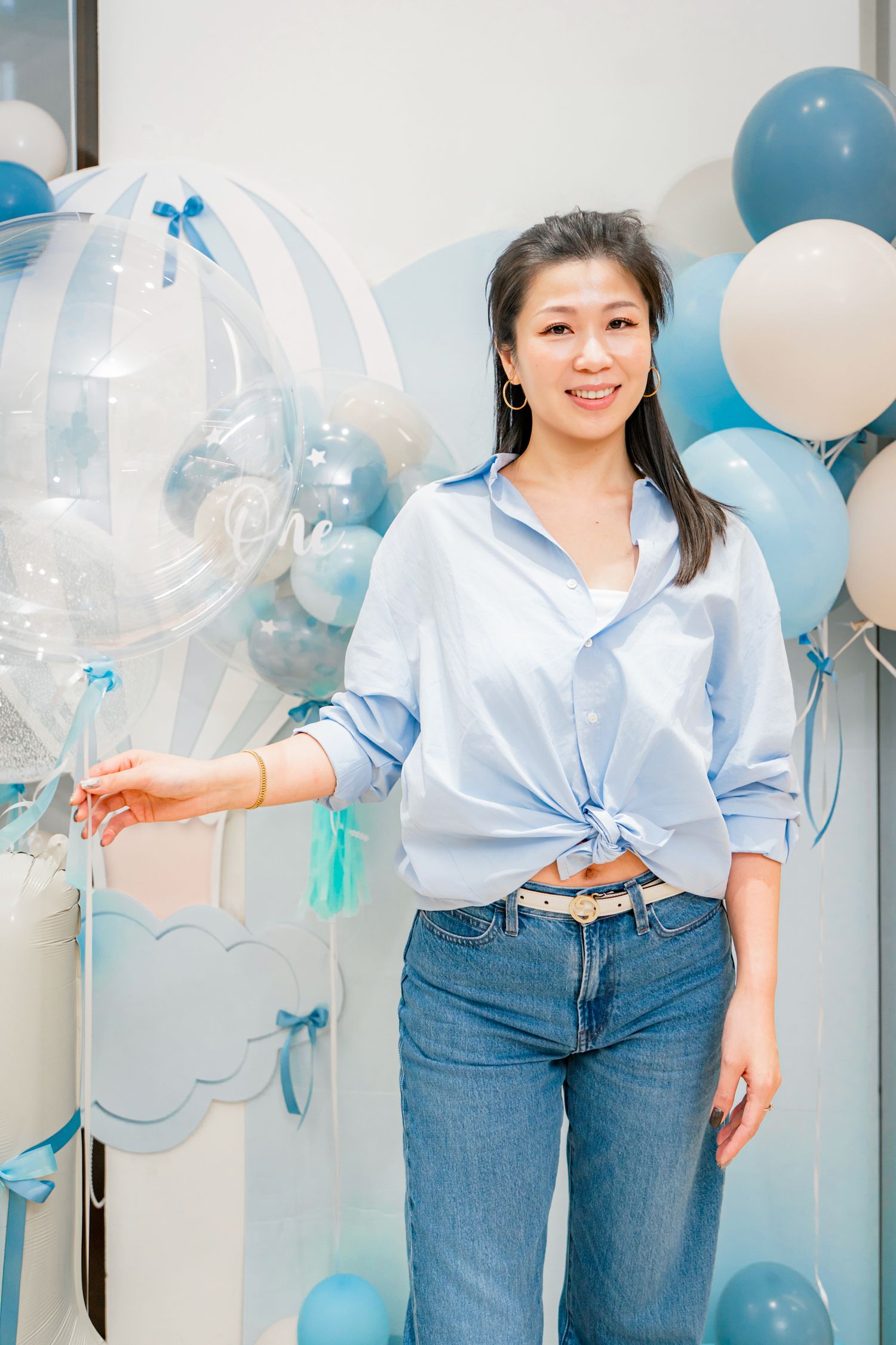 Decorative party setup with blue and white balloons creating a festive atmosphere against a light background.