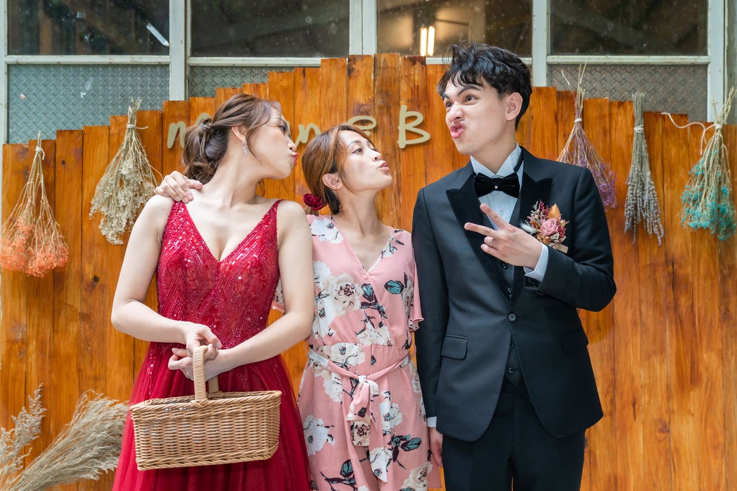 A candid moment captured against an orange backdrop with formal attire and a wicker basket.