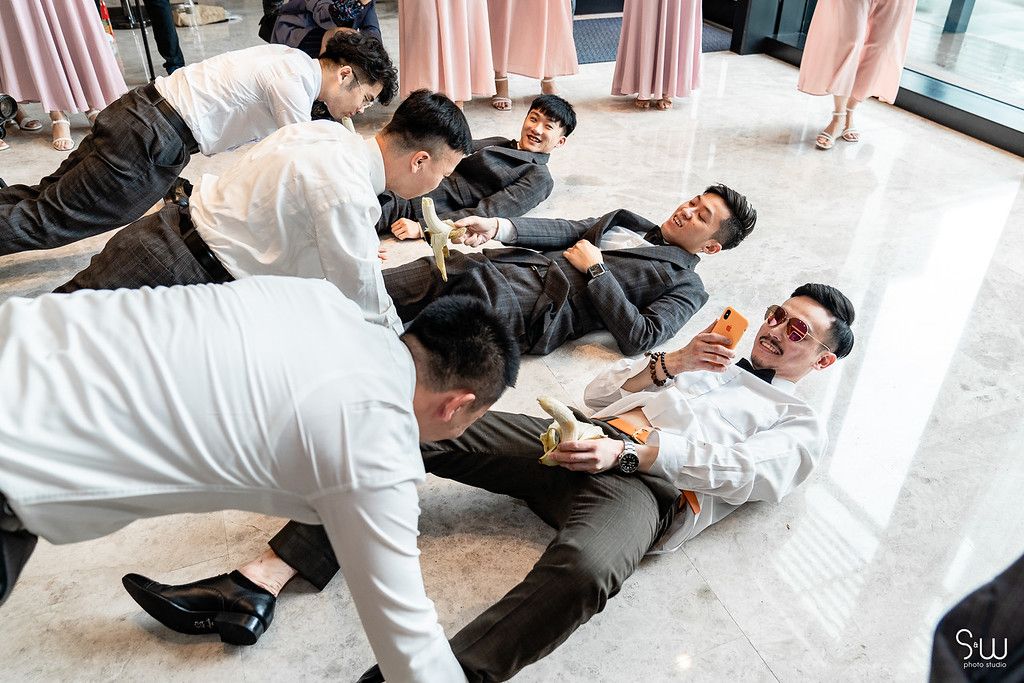 Wedding party members participate in floor games during reception festivities.