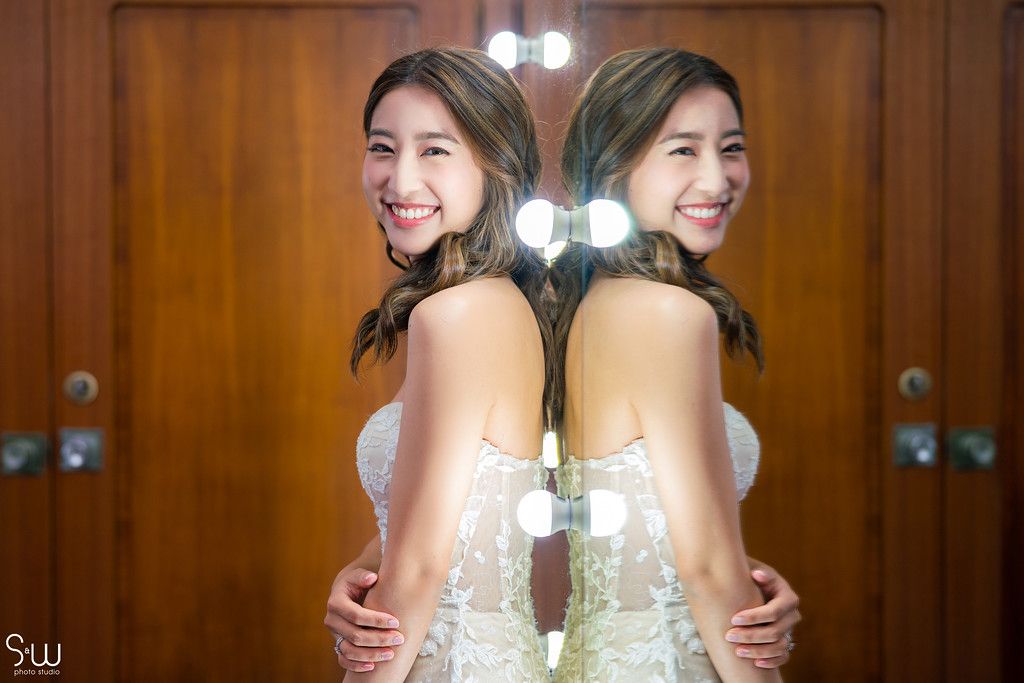 Creative mirror reflection bridal portrait showing back-to-back poses in elegant setting.