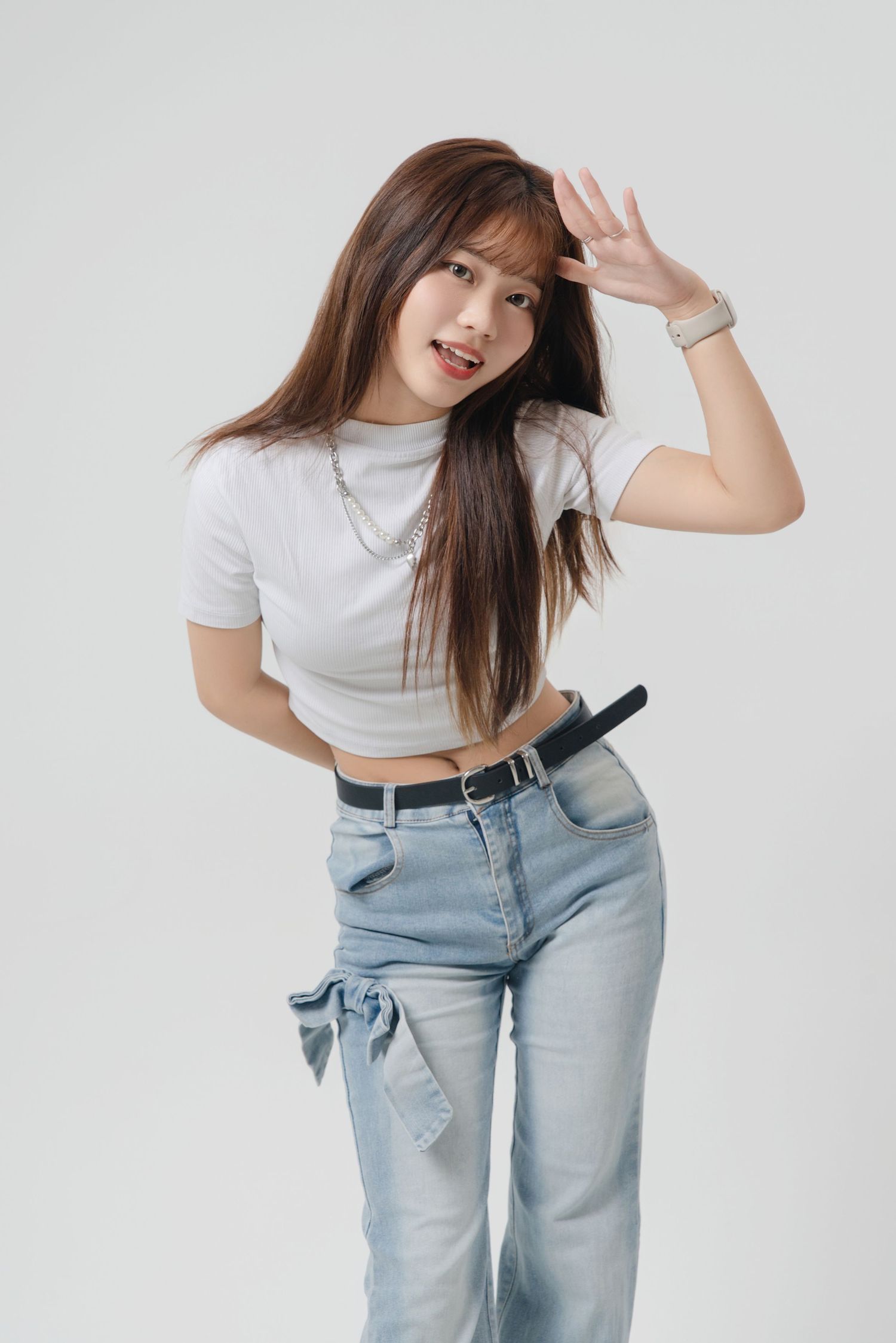 A person in a white crop top and light blue jeans poses playfully in a series of casual fashion shots.