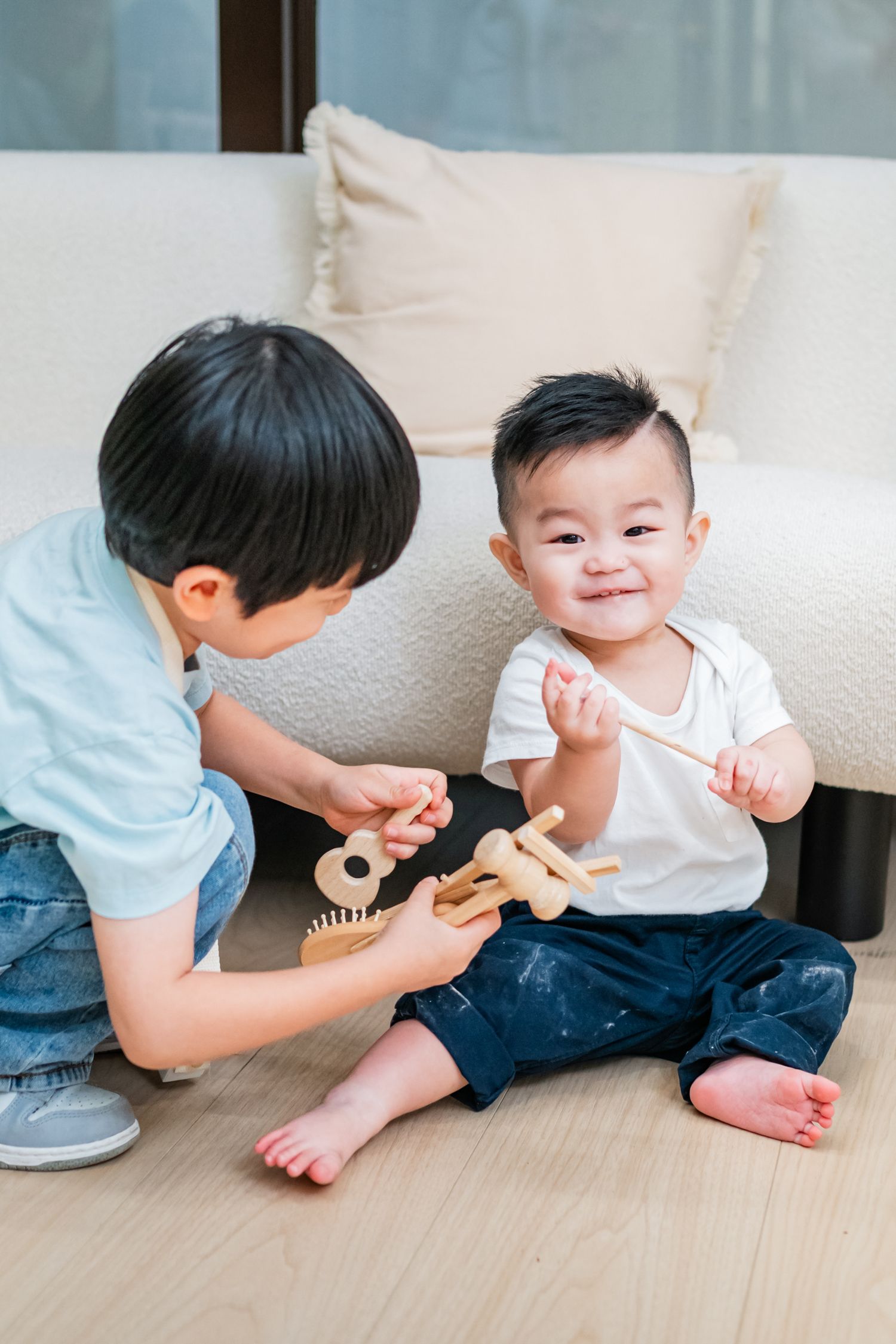 A parent and child sitting on the floor playing together with wooden toys in a series of connected photos.