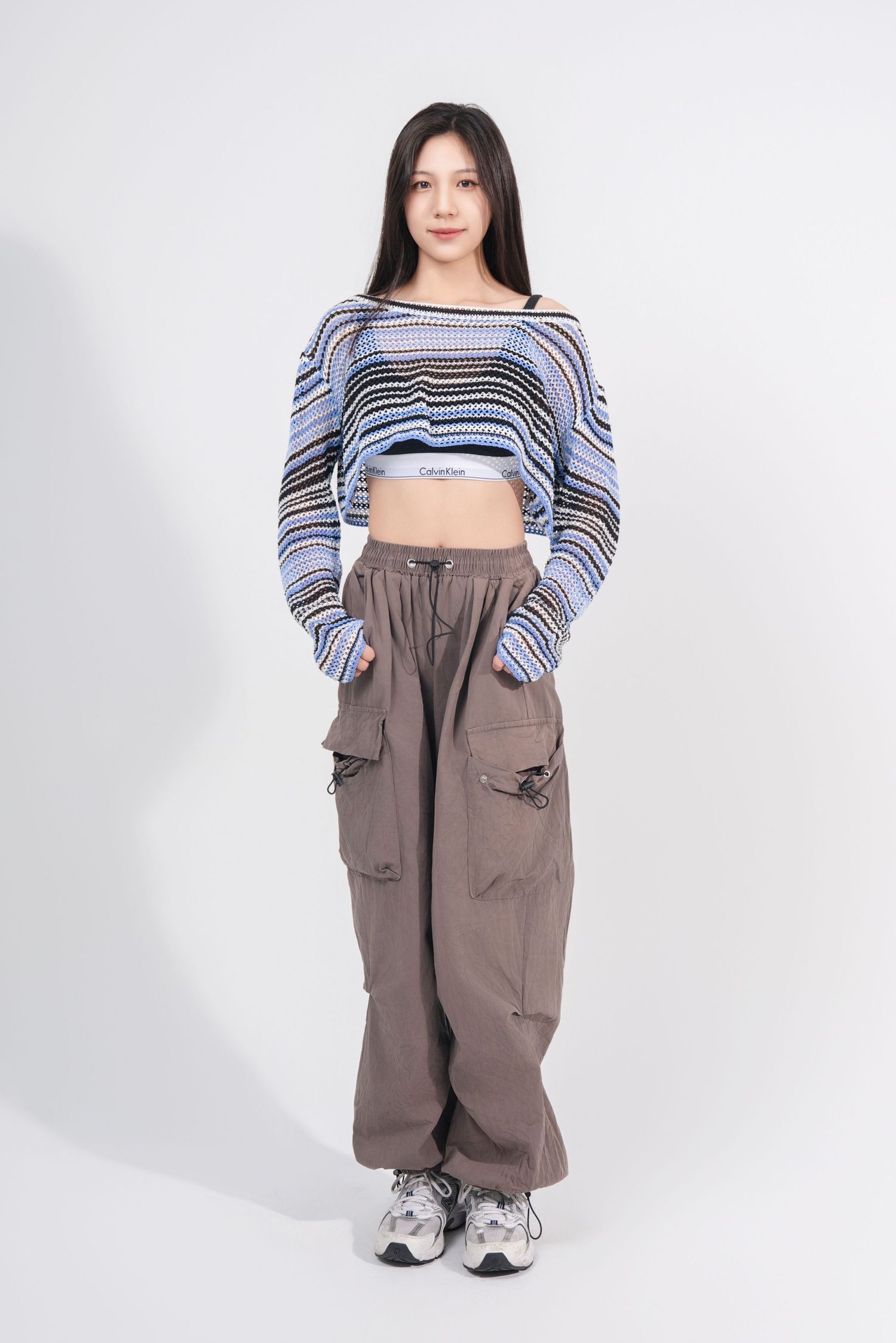 Model wearing a striped crop top and baggy cargo pants poses in different angles against a white background.