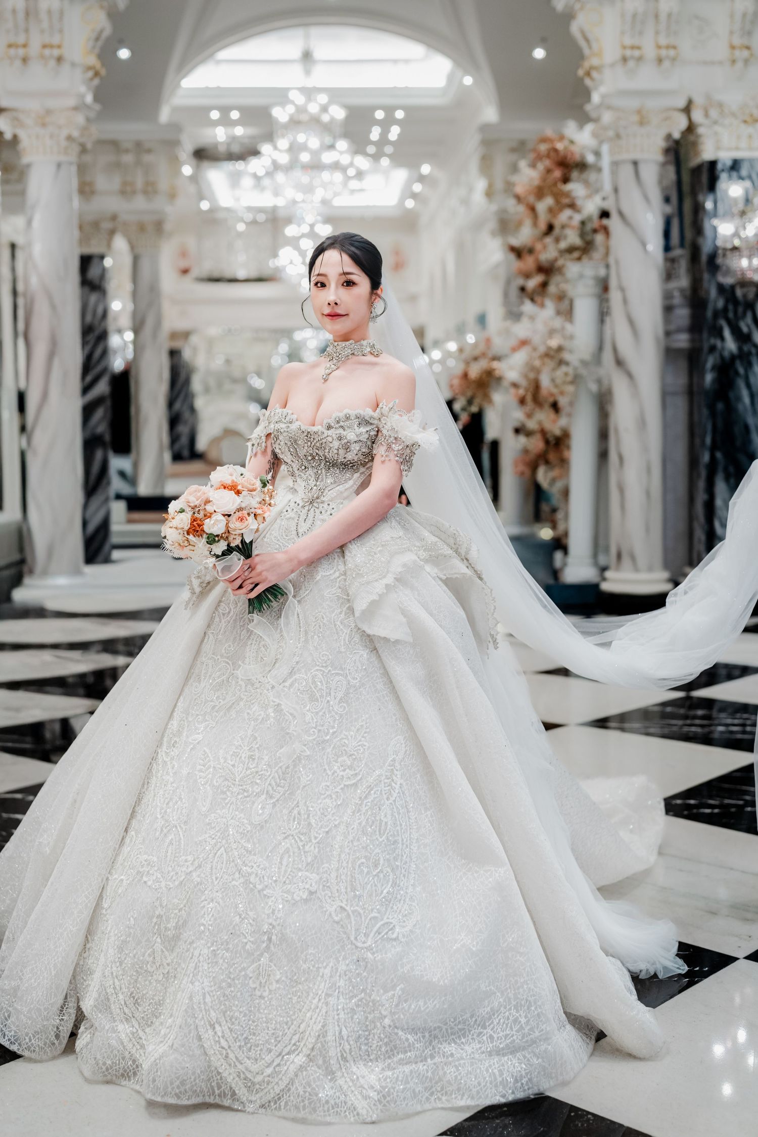 Luxurious white wedding gown with sparkly embellishments and full skirt displayed in an elegant bridal boutique setting.