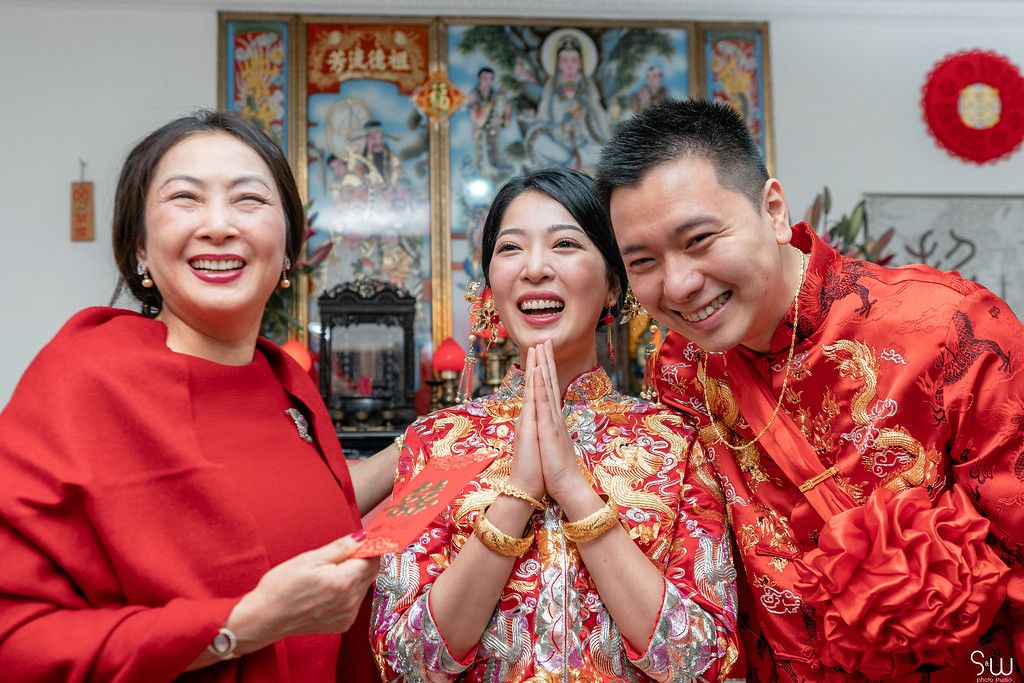 Joyful celebration moment during Chinese wedding ceremony with traditional red attire.