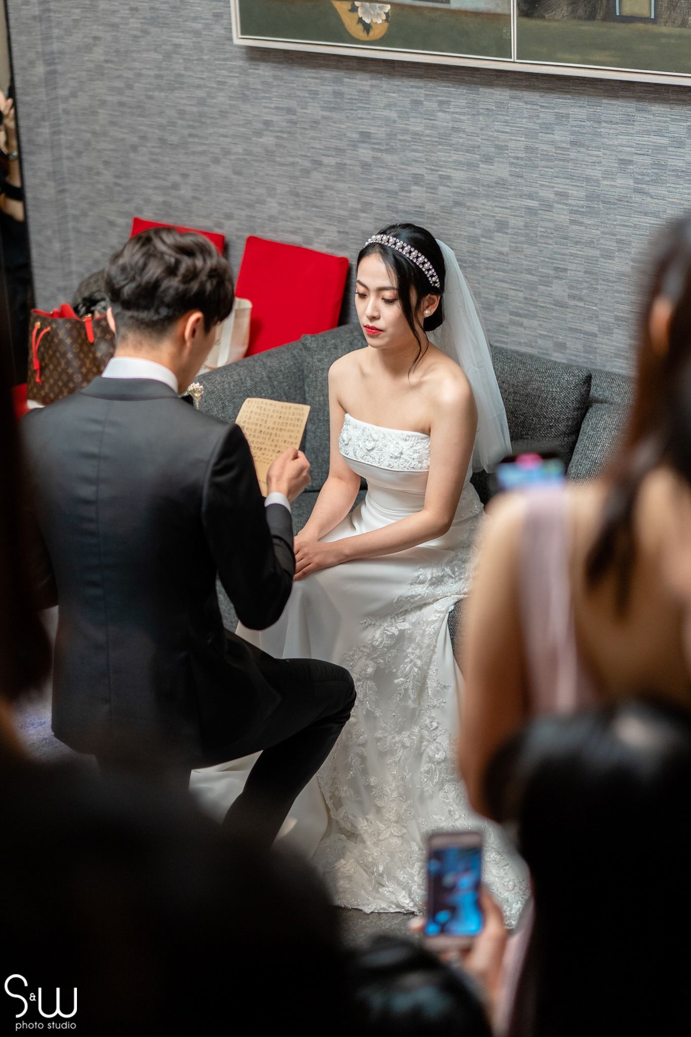 A wedding ceremony moment with guests capturing the emotional scene on their phones.