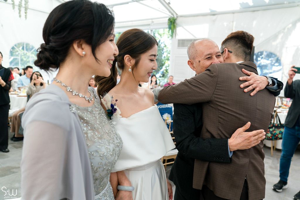 Intimate family moment during wedding celebration with emotional embraces.