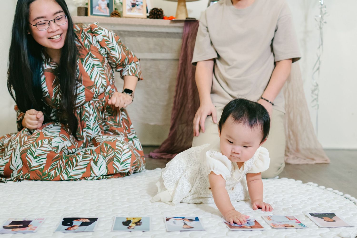 Parent and child engage in arts and crafts activities at home with colorful art supplies and materials spread across a table.