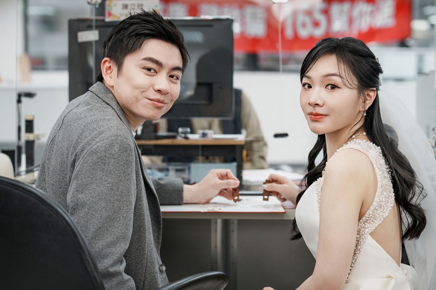 Young couple enjoying coffee together at a casual cafe, sitting at a small table and smiling at the camera.