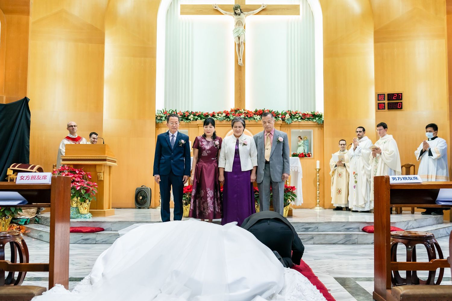 A traditional Catholic wedding ceremony with clergy and attendees gathering at the decorated altar.