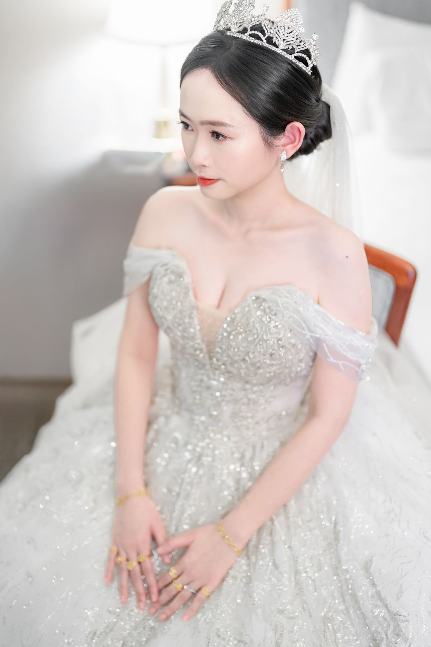 A bride in a sparkling silver ballgown poses elegantly in a series of detail shots showcasing the dress's intricate beadwork.