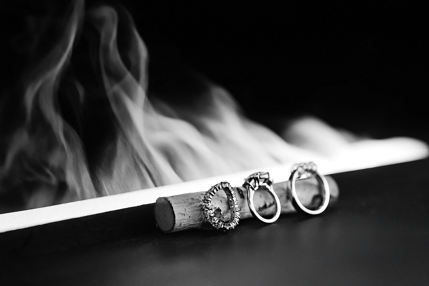 A close-up series of images showing cigarette smoke rising and curling in artistic black and white patterns.