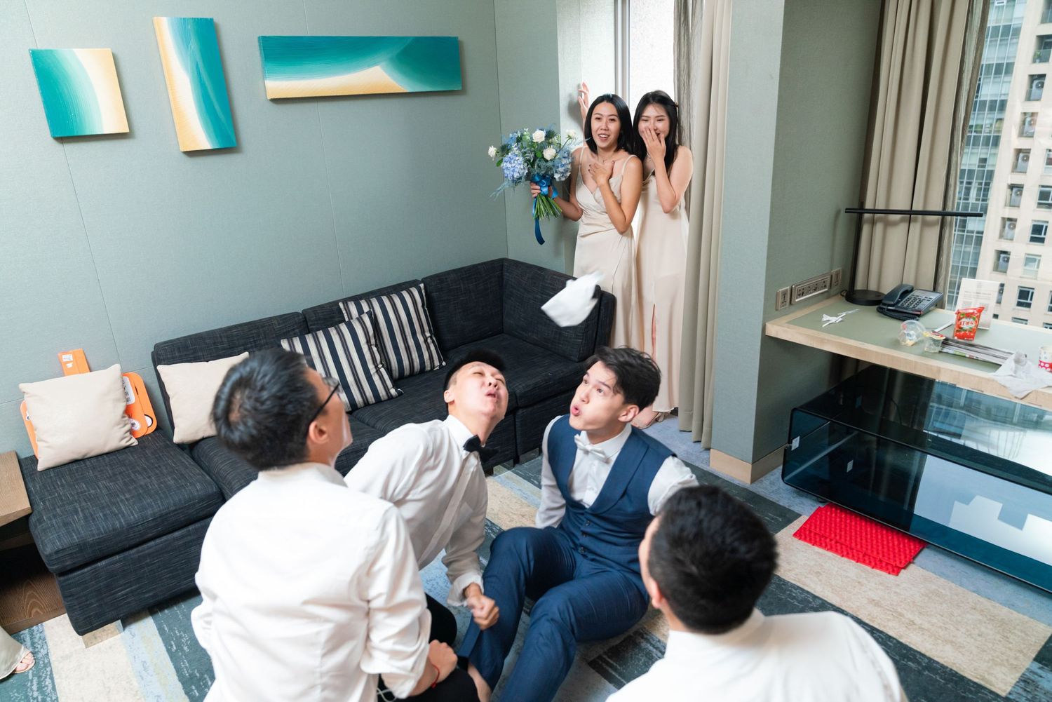 People in a modern apartment gathering around a couch enjoy a casual social moment together.