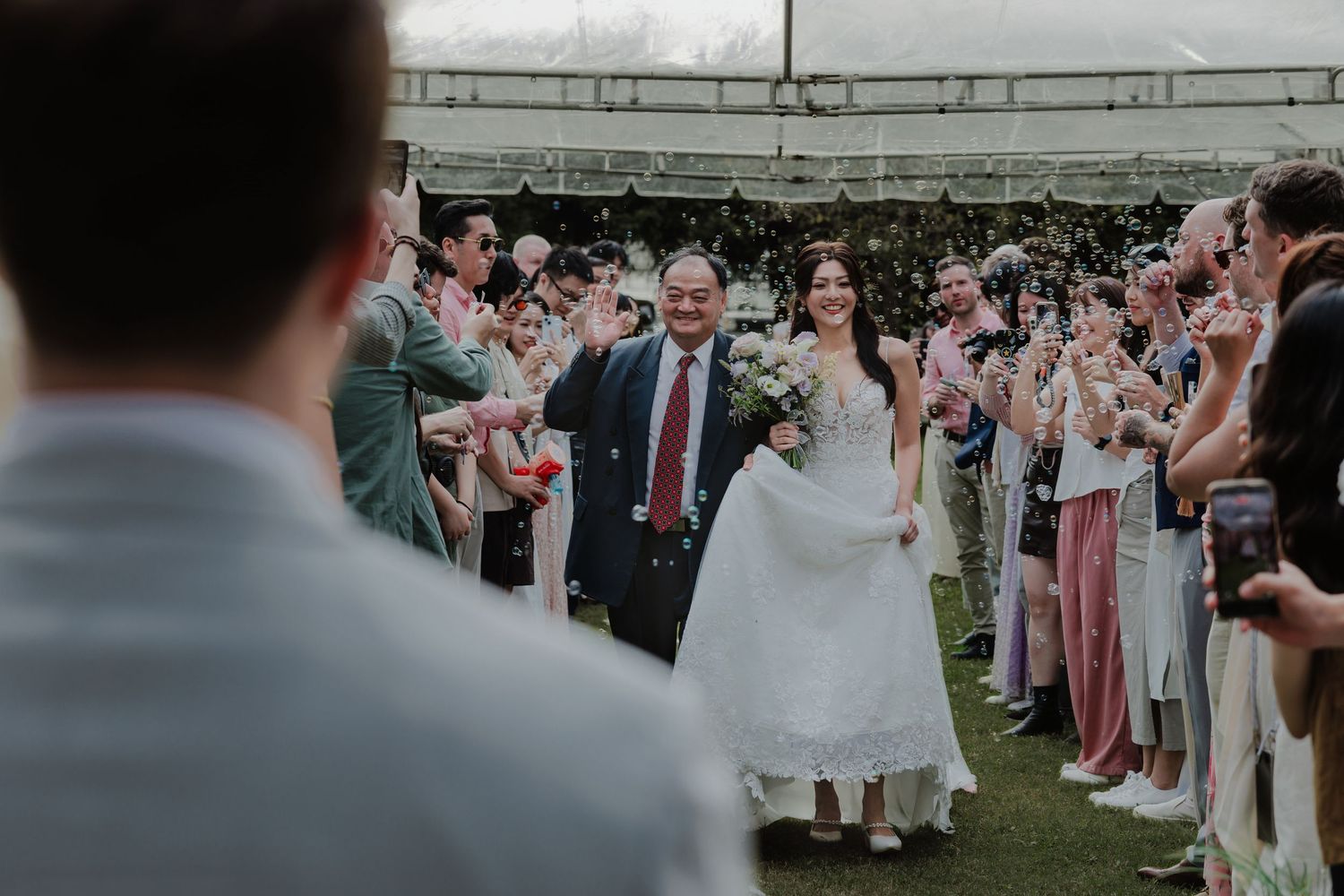 Bride walks with escort through confetti shower as wedding guests celebrate outdoors at elegant garden ceremony.台北婚禮攝影
婚禮攝影師
戶外婚禮
婚禮紀實
婚攝推薦