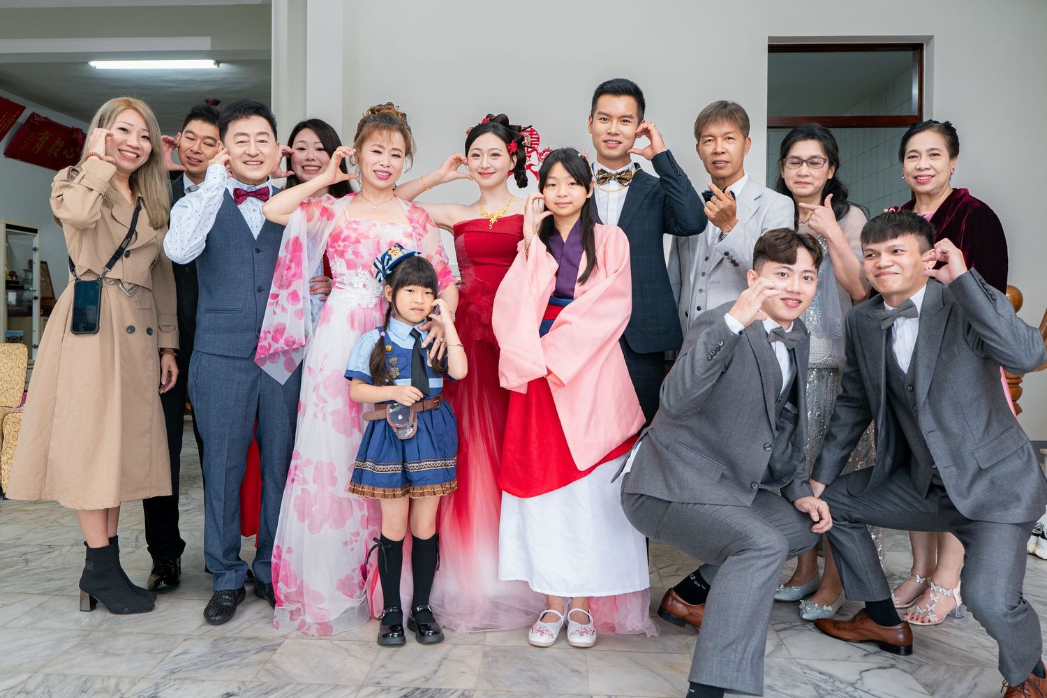 Group photo of smiling family in traditional Korean and formal attire at a wedding celebration.