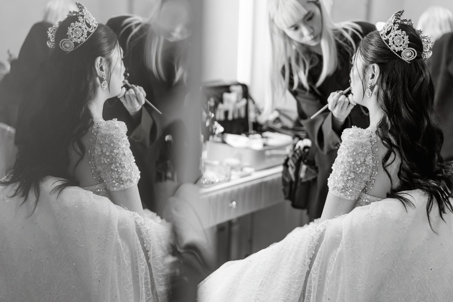 Black and white photograph showing preparation at a dressing table with mirror reflections and elegant white lace robes.