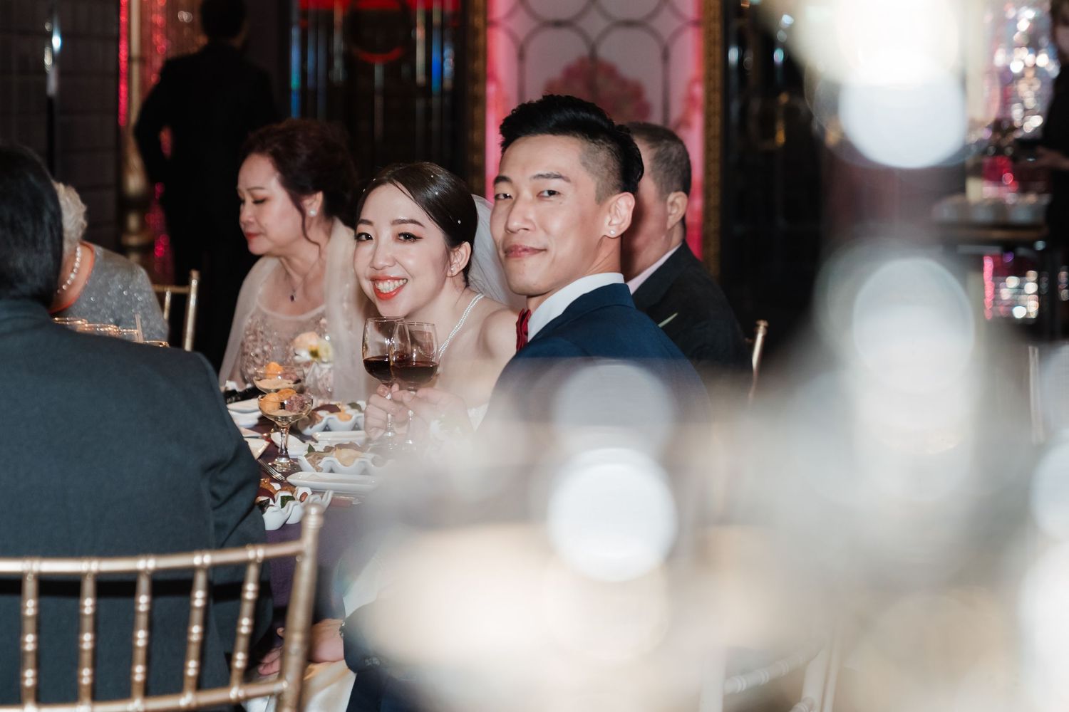 A wedding reception moment captured through soft bokeh lighting at an elegant indoor venue.