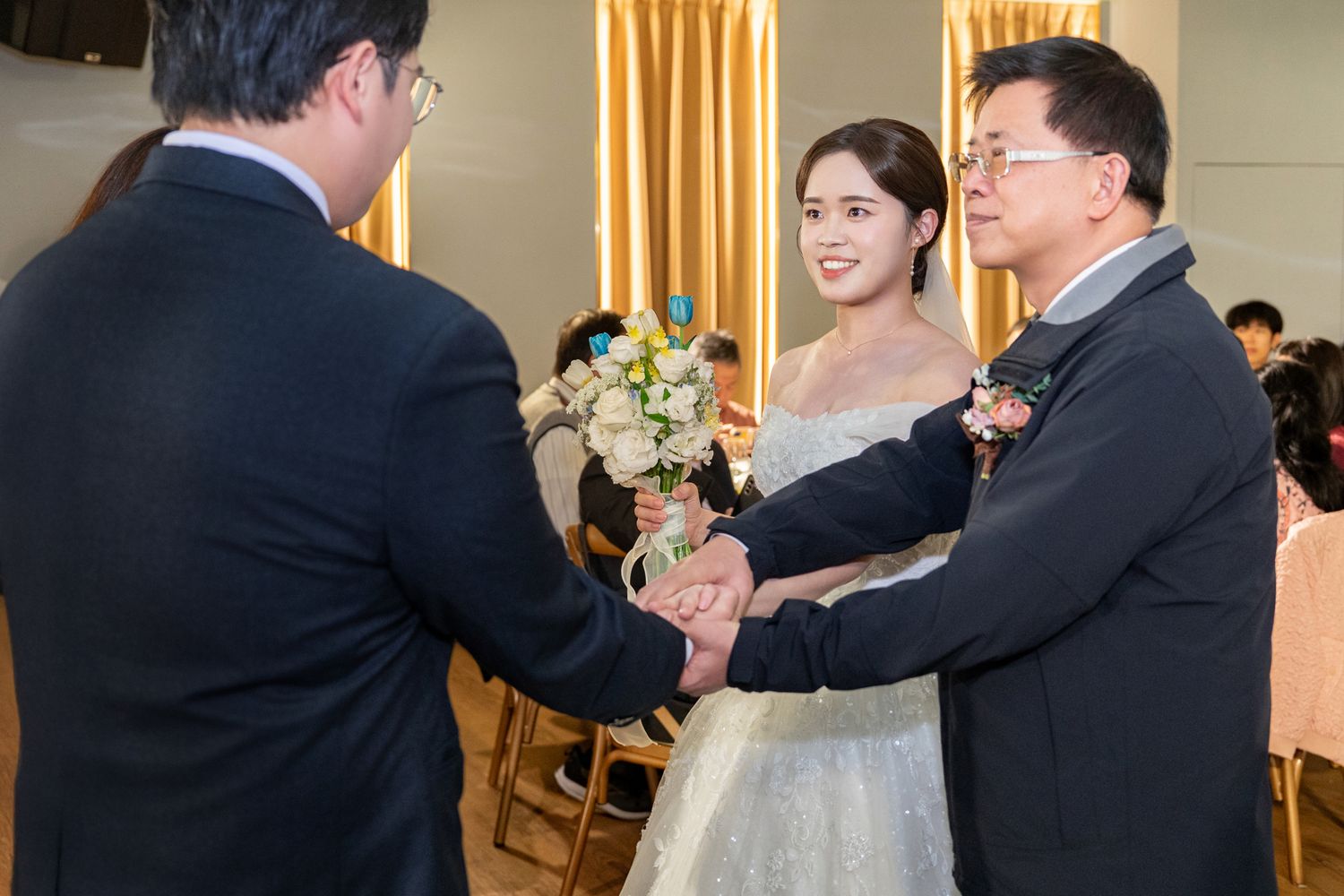 A couple shares a tender moment during their first dance at an elegant wedding reception with warm lighting.