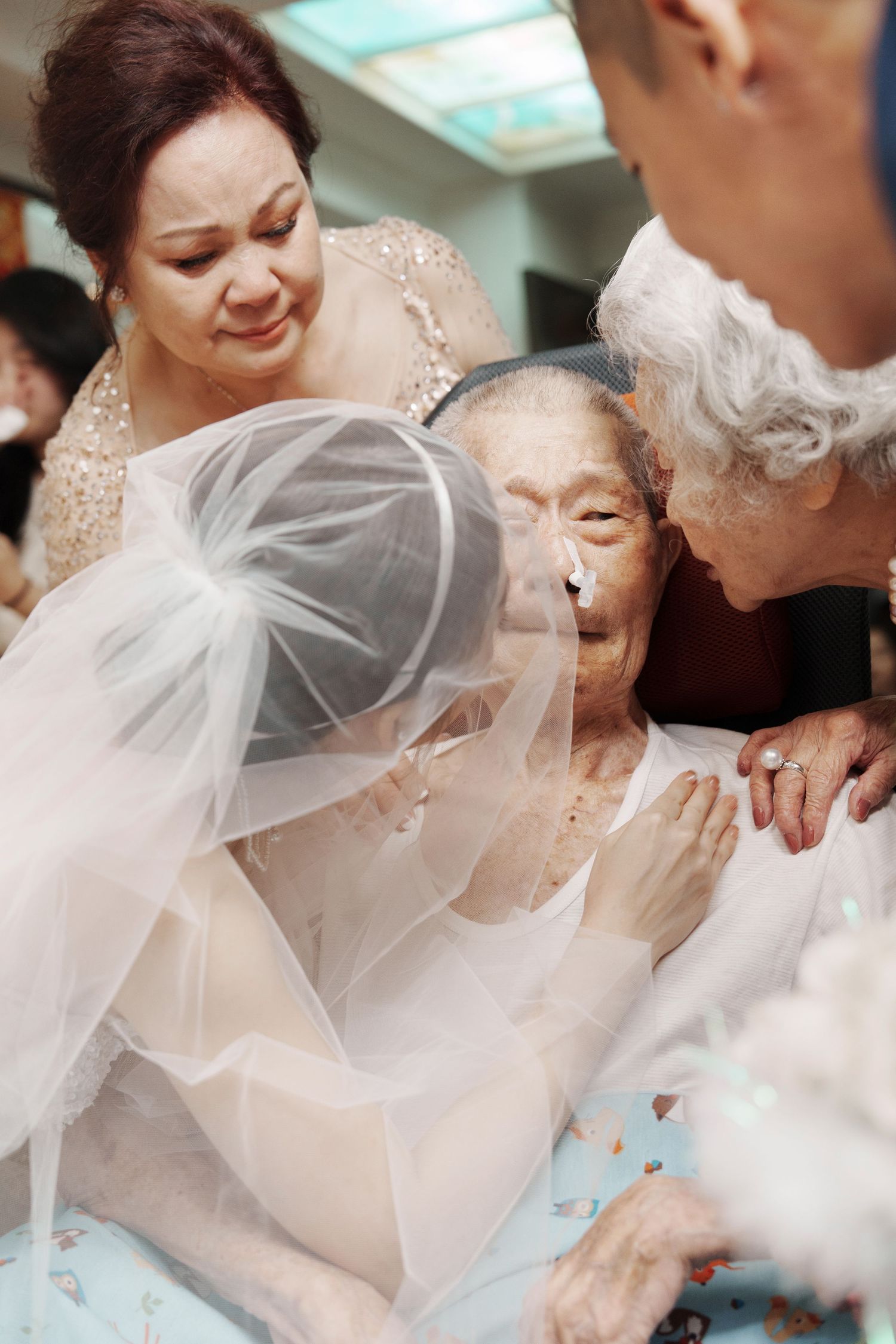 An emotional family moment captured around a hospital bed during a wedding celebration.